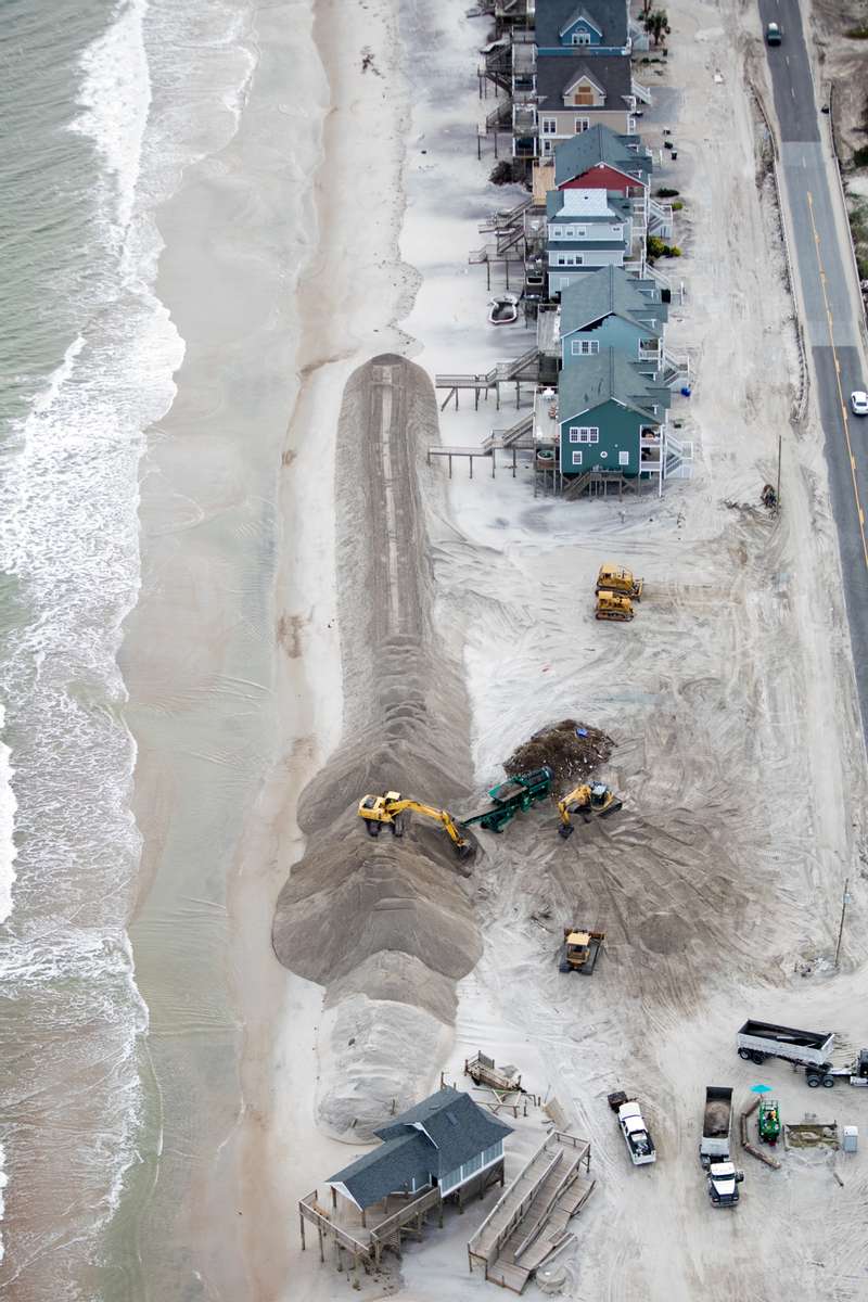 Dune restoration in North Topsail Beach, North Carolina after Hurricane Florence battered coastal homes and washed away sand. After waiting years for federal funding, the town funded its own dune rebuilding, costing millions of dollars.