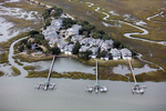 A gated community on Pea Island, near Charleston, South Carolina. Houses are elevated, with garages on ground level. Community docks provide access to the ocean, out through the lagoon.