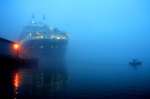The Queen Mary II docks in Red Hook Brooklyn. 5am fog surrounds the scene as a patrol boat secures the area.