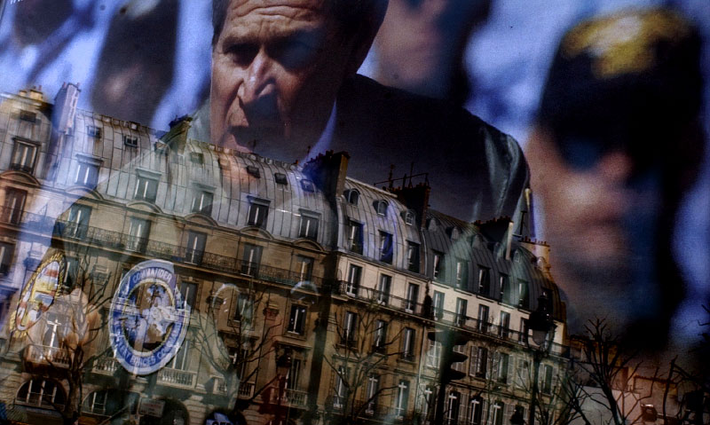 Parisian buildings reflect onto a poster of George W. Bush in a photo for a March 23, 2003 Hartford Courant story documenting Parisian reactions to the Bush administration in the era of Freedom Fries and negative reactions to France in the States.