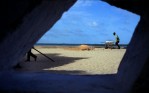 A man pushes a wheel barrow on the shores of the Indian Ocean on the Island of Lamu in Kenya in August of 2001.