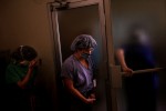 Registered Nurse Kathy Aries, center, pauses in a surgical unit before assisting in a surgery.