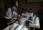 Richard Days, 78, kisses the hand of Ken Carter, 74, after Martin played saxophone for him at St. Francis Hospital and Medical Center. Martin, a former professional musician, suffered a stroke 18 years ago and learned to play the saxaphone with one hand after his stroke. The Bloomfield resident volunteers at St. Francis and plays his saxaphone for people who are in the hospital, as well as at Mount Sinai Rehabilitation Hospital. {quote}That was a blessing - him walking in my door,{quote} said Days, who is also a resident of Bloomfield and knows Martin who said with admiration, {quote}How many one-armed saxaphone players do you know?{quote}