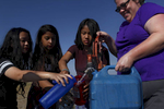 (l-r) Sumina Magar, 14, Sostika Chhetri, 14, Dechen Drukpa, 14, and Jamie Stanley, 33, gather water before making dinner at their campsite in Hooper, Colo. on Sept. 3, 2017. Stanley is the Venturing Crew advisor and is from Denver.