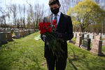 Malden, MA - 4/29/20 - Matt Tauro holds onto roses to give out to family members at Holy Cross Cemetery for Annette Nazzaro's funeral. Nazzaro, who lived to be 100, died of coronavirus or COVID-19. (Jessica Rinaldi/Globe Staff) 