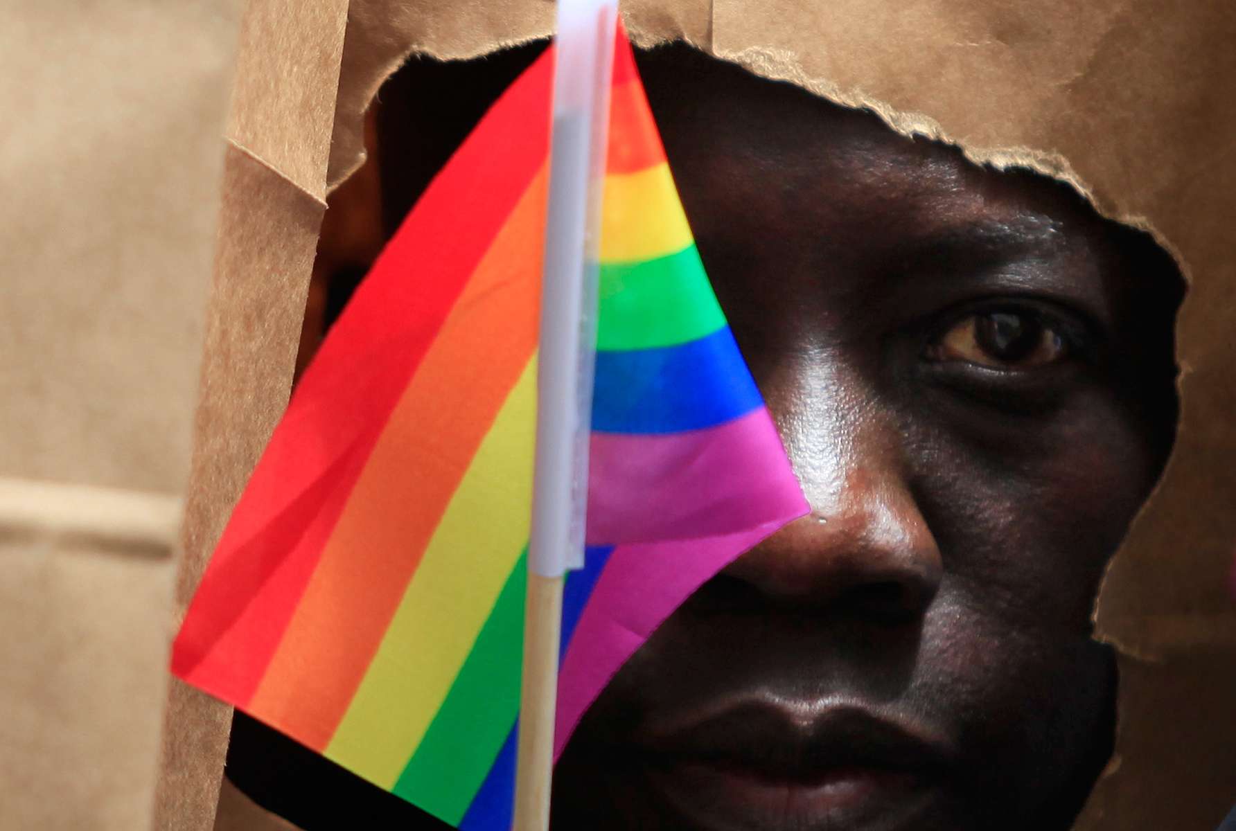 An asylum seeker from Uganda covers his face with a paper bag in order to protect his identity as he marches with the LGBT Asylum Support Task Force during the Gay Pride Parade in Boston, Massachusetts June 8, 2013. Homosexuality in Uganda is illegal and carries a potential penalty of life in prison.