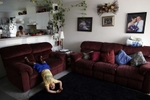 Eloy Cervantes, Jr., 6, plays while his older sister, Itai, 13, cleans the house and takes care of chores while their parents are at work in Mattawa, Wash., Aug. 23, 2013.Their parents Eloy and Flor Cervantes, have been in America for almost 20 years. Three of their four children were born in the United States and citizenship — or the lack of it — is constantly threatening to separate them. They say citizenship would be a solution for what has become a permanent way of life.