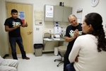 (L-R):  Medical Assistant Genaro Jimenez translates Dr. Daniel Sloane's question to Maria Granados inside the Mattawa Community Medical Clinic where Maria came after she fell from a ladder with a half full bag of apples after picking in the orchards in Mattawa, Washington, August 24, 2013.