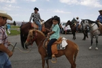Juan Erazo, left, holds the lead line of his son, Azel's pony, Carinoso, as they ride during the Mattawa Community Day parade in Mattawa, Washington August 24, 2013. A few years ago, the city had canceled the longtime celebration because there were too few volunteers. But Maggie Celaya, a city councilor, and her sister, Lola Cruz, who teaches citizenship classes, worked to bring it back in 2012.