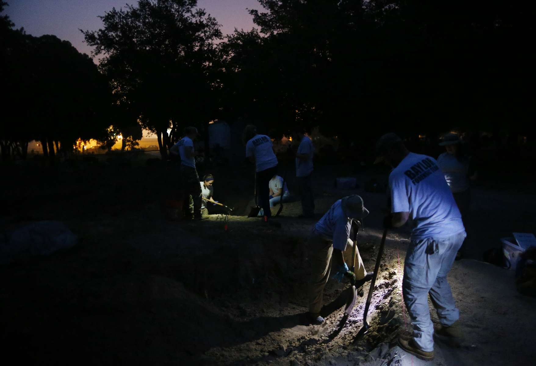 Falfurrias, Texas - Members of the Baylor forensics team and the University of Indianapolis Archeology and Forensics Laboratory shine flashlights so that their colleagues can start digging before the sun comes up as they work to exhume bodies of unidentified migrants who apparently died crossing the border and ended up buried anonymously in a pauper's grave in Falfurrias, Texas June 11, 2014. 