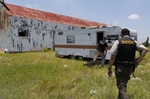 Falfurrias, Texas -  Cameron Coleman of the Hidalgo County Sheriff's Department (L) and Daniel Walden Chief of Dona ISD Police Department walk towards a trailer where migrants are known to wait and watch the street as they make their trek through a ranch in Falfurrias, Texas June 11, 2014. Both officers are part of Brooks County Sheriff's Office Rescue Posse an effort by local police to help lend an additional hand to Falfurrias who is understaffed and underfunded. 