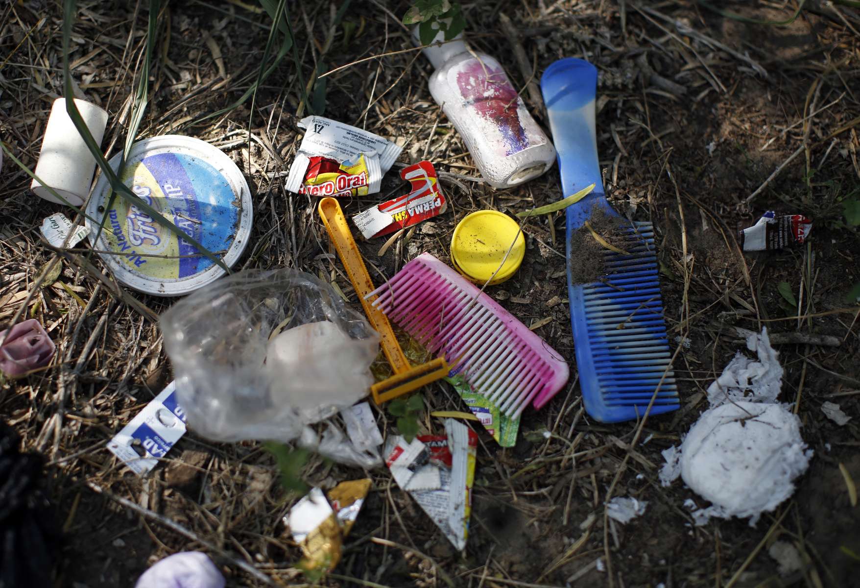 Falfurrias, Texas -  Toiletries left behind by a migrant are seen scattered in the grass on a ranch in Falfurrias, Texas June 12, 2014. 