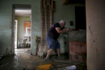 Toa Baja, Puerto Rico -- 9/30/2017 -  In Toa Baja, on the island’s northern coast, bulldozers worked to clear mud from the streets as families were digging out, trying to salvage the few belongings that were left. Geraldo Rivera, 51, helps his neighbor move heavy furniture out of his home which was ruined by flood waters. 