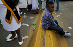 Selma, Alabama -- 3/08/2015-- A boy sits on the dividing line of the Edmund Pettus Bridge as marchers retrace the steps of those who marched with Dr. Martin Luther King, Jr. 50 years ago in Selma, Alabama March 8, 2015. 