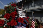 Neighbors place a photo of the victims of the shootings at Fort Hood on top of a wreath of flowers set up as a memorial in the courtyard of the apartment complex where suspected shooter, Major Nidal Malik Hasan, lived in Killeen, Texas November 9, 2009. Thirteen people died in the mass shooting Thursday at the sprawling U.S. Army base in Texas.