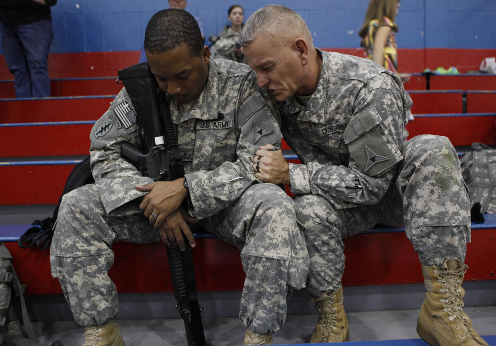 Lt. Col. Houck and  Army Warrant Officer Carlton Royster, 30, of Philadelphia, pray together during a farewell event for the III Corps Special Troops Battalion on the verge of deploying to Iraq. It was the first deployment to take place after the shootings at Fort Hood.