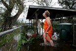 Gail Meads looks for her cat which climbed up into a tree as she stands in her backyard ankle deep in floodwaters caused by Hurricane Ike in Galveston, Texas September 13, 2008.