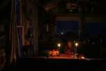 Belfast, ME, 04/29/2019 --  After a long day Etta Hughes, 11, rests her head on the kitchen table as she and her sister, Isla, 7, play a card game by candle light at their permaculture homestead in Maine. The Hughes family doesn't use electricity which is part of their petroleum-free, off-the-grid community in Maine called The Possibility Alliance.  