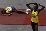 Second place finisher Dire Tune, of Ethiopia, (L) falls to the ground as Women's winner Salina Kosgei, of Kenya, walks away after crossing the finish line of the 113th running of the Boston Marathon in Boston, Massachusetts April 20, 2009.