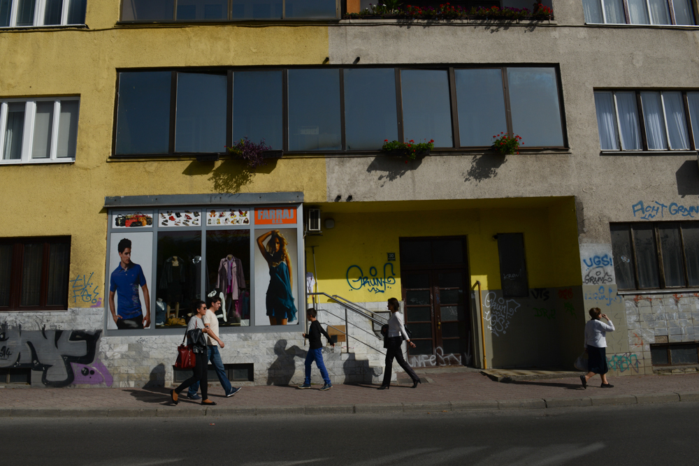 SARAJEVO, BOSNIA AND HERZEGOVINA.  People walk passed a building that shows a lack of certainty with regard to the facade's colors and windows on October 11, 2014.  As Sarajevo was restored after the 1992-1995 siege according to private property regulations as opposed to the previous state order which allowed for less dissonance and continuity of styles.
