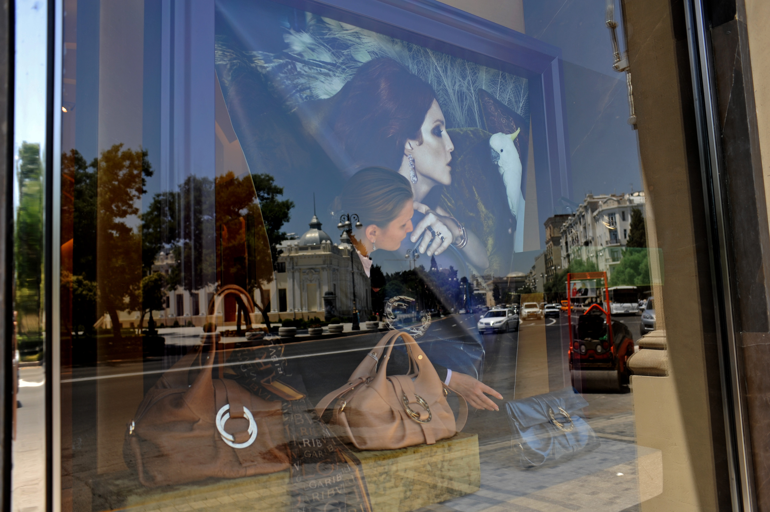 BAKU, AZERBAIJAN.  A saleswoman adjusts the window display at Bulgari on Neftiler Prospekt, or Oil Worker's Boulevard on July 2, 2010.  Luxury shopping in downtown Baku is one symptom of the city within the city or the country within the country where the elite, estimated at 50,000, control much of the country's income and profit from oil revenues, leaving a wide gap in the absence of a middle class between them and the rest of the country.