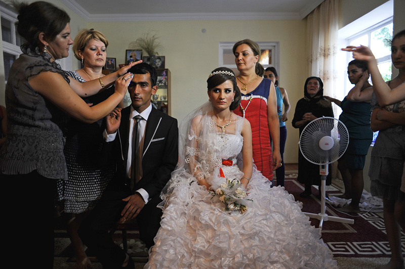 GIVRAKH, NAKHCHIVAN AUTONOMOUS REGION, AZERBAIJAN.  Farid Aliyev, 23, and Khanim Veliyeva, 20, pose for pictures in his home on the third day of a traditional three day wedding on July 15, 2012.   Once the bride is delivered to the groom's family's house, she will stay with the family and live the rest of her life in her new home.