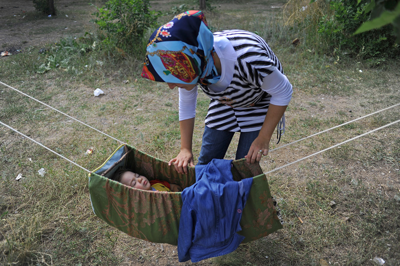 ERZURUM, TURKEY.  A Turkish picnicker rocks her child as he sleeps in a hammock at a site near the Ataturk University in Erzurum, Turkey, the first major city near the route of the Baku-Tbilisi-Ceyhan oil pipeline in Turkey, located just 10 kilometers from the pipeline which traverses numerous villages near the city's airport, on August 8, 2010.