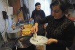 KODA, GEORGIA.  (Left) Venera Arbolishvili, 75, cooks dinner for her extended family with her daughter in the kitchen of her new home in the internally displaced persons (IDP) settlement in Koda, Kvemo Kartli, Georgia on January 20, 2012.  Originally from the village of Eredvi in South Ossetia, formerly a territory of Georgia which was lost to the Russians during the 2008 August War, Arbolishvili said during the war, an unknown assailant fired from a car and killed her husband who died in her arms and subsequently she was forced to flee her home before she could bury him.