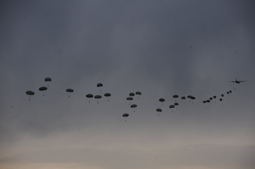 SWIDWIN AIRFIELD, POLAND.  An airdrop of American soldiers in the 1st Battalion, 503rd Infantry Regiment, 173rd Airborne Brigade parachute in from a C-130 during an airfield seizure exercise on June 16, 2015.  NATO is engaged in a multilateral training exercise {quote}Saber Strike,{quote} the first time Poland has hosted such war games, involving the militaries of Canada, Denmark, Germany, Poland, and the United States.
