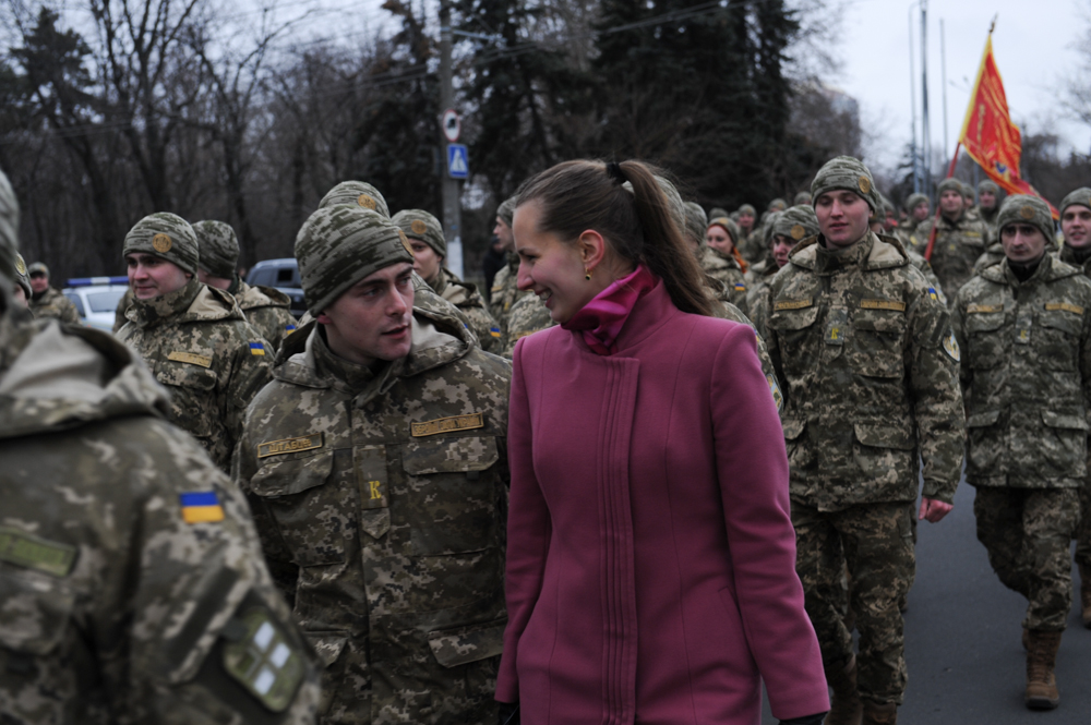 ODESSA, UKRAINE.  A Military Academy student marches down the street with a young woman beside him to a ceremony at the April 10 Monument where the student soldiers will be promoted to the rank of lieutenant on February 26, 2016.  With war raging in eastern Ukraine with Russian-backed separatists, more young men and women have enlisted and the popularity of military education has increased, including among civilians; the April 10 monument commemorates Soviet victory over the Nazi occupation in Odessa.