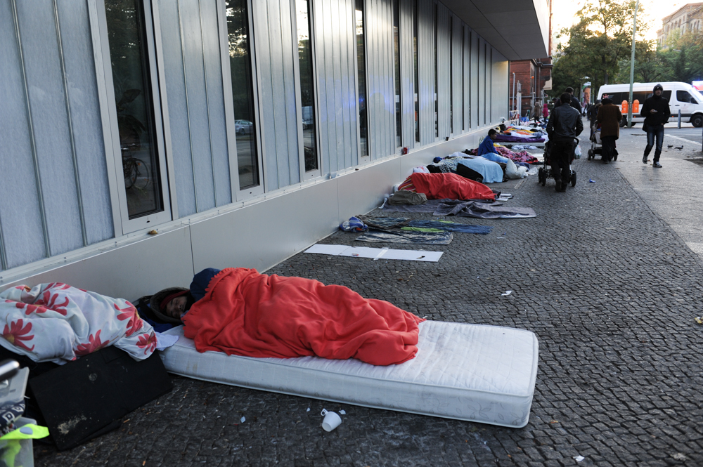 BERLIN, GERMANY.  Men from Afghanistan and Pakistan sleep on Turmstrasse (Turm Street) in front of the office of Landesamt für Gesundheit und Soziales (LaGeSo), the State Office for Health and Social Services, where refugees and asylum applicants arriving in Berlin must go to register their application for asylum, in the Moabit district on September 28, 2015.  German Chancellor Angela Merkel has said Germany will take 850,000 asylum applicants this year as many fleeing conflicts in Syria, Iraq, Afghanistan, Pakistan and elsewhere have migrated in mass to Europe through the Western Balkans seeking safety and a future.