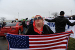 BLOOMINGTON, ILLINOIS.  A Trump supporter revels beside a much larger crowd of demonstrators outside the Synergy Flight Center as Republican front runner Donald Trump speaks on March 13, 2016.