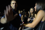 BELGRADE, SERBIA.  A door guard objects to photos as young women wait to enter River, a club on a splav, or barge, on the Sava River ahead of a concert by Jelena Karleusa on the night of July 3, 2015.  The splavs along the Sava and Danube Rivers are the epicenter of Belgrade's raging all night club scene; Karleusa is one of two of the turbofolk industry's greatest stars and certainly its most outspoken liberal voice and advocate for the gay community.