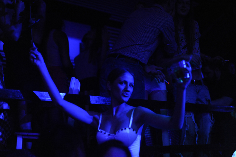 BELGRADE, SERBIA.  A clubgoer at Bard, a nightclub on a splav or barge on the Danube River, dances to fast-paced turbofolk hits by Dara Bubamara on the main dance floor of the club on July 8, 2015.  Dara Bubamara's career extends back to 1989 when she got her start on television singing songs by Lepa Brena.