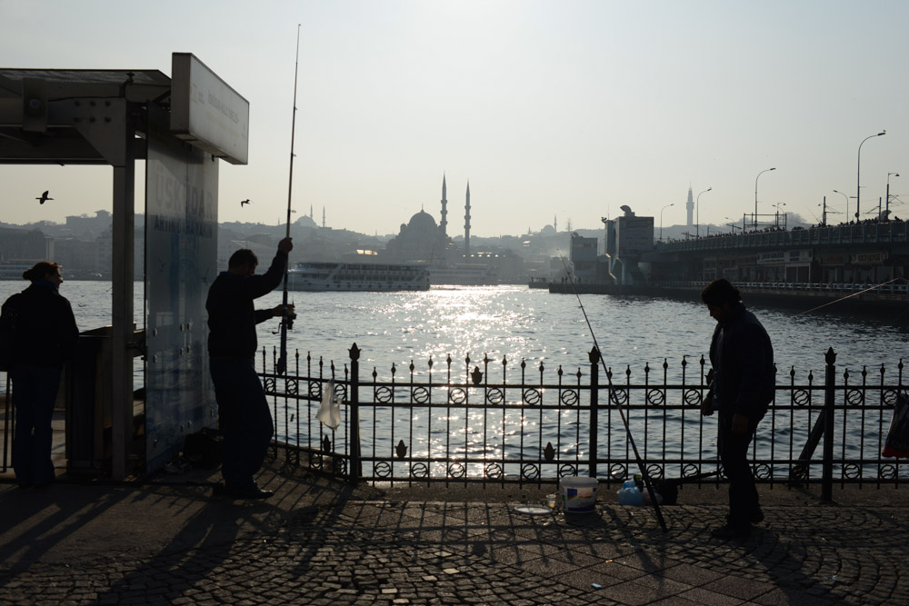 ISTANBUL, TURKEY.  Fisherman are seen on the Karakoy shore beside the Galata Bridge on January 11, 2014.