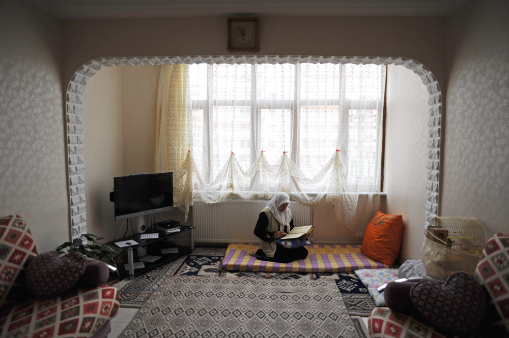 DIYARBAKIR, TURKEY.  A Kurdish woman reads from the Koran in her living room after having recently returned from a pilgrimmage to Mecca on February 28, 2012.