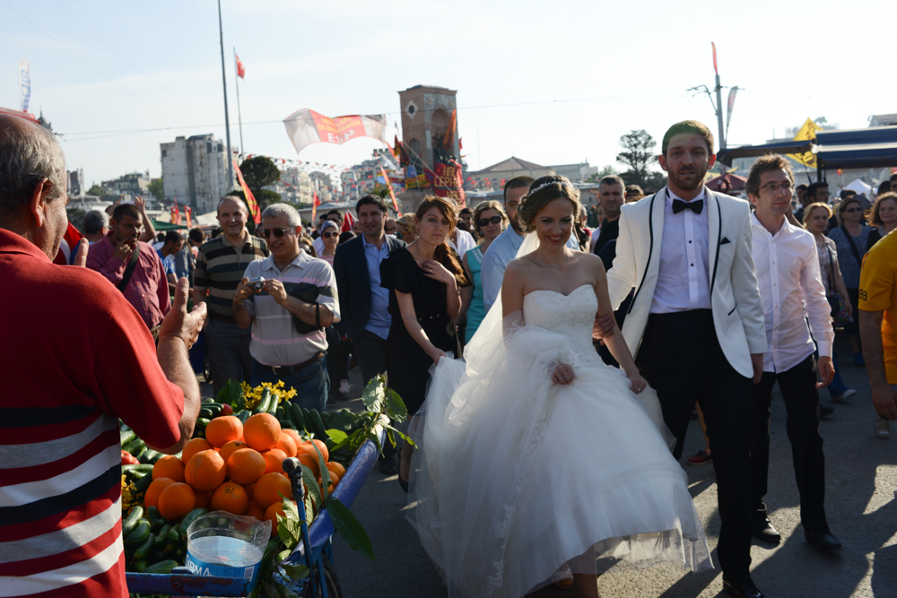 ISTANBUL, TURKEY.  A bride and groom promenade in Taksim Square in protest of the Prime Minister Recep Tayyip Erdogan and his policies a week after demonstrators forced police to withdraw from the square leading to a carnival-like sit-in on June 8, 2013. A week of protests led to police being barricaded out of and withdrawing from Istanbul's Taksim Square as it transforms increasingly into a free zone; the crisis, which began over construction of a park and plans to reconstruct Ottoman barracks and a shopping mall, has evolved into Turkey's biggest political crisis in decades as Turks express frustration with the current AK Party, Justice and Development Party and Prime Minister Recep Tayyip Erdogan.