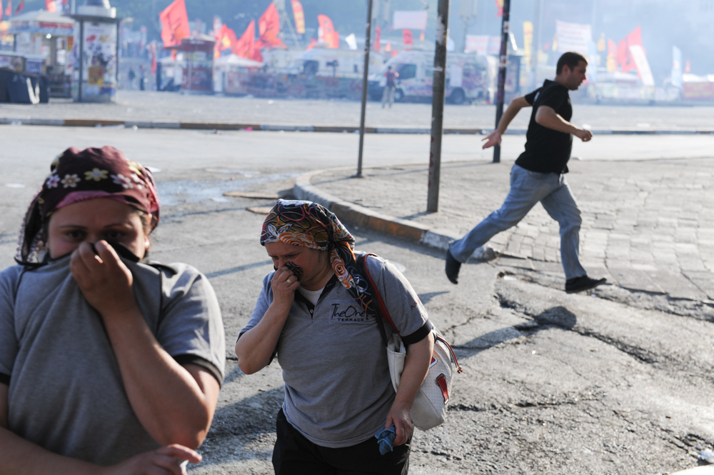 ISTANBUL, TURKEY.  Women react to the tear gas in Taksim Square as riot police move on the square on June 11, 2013. After 10 days of protest and occupying Gezi Park adjacent to Taksim Square, riot police moved to retake the square; last night, the Prime Minister called a meeting for tomorrow with protest leaders.