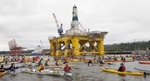 Activists in kayaks protest against oil drilling. 
