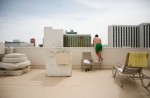 A sunbather takes a peak over the ledge of the 5th floor pool area to look down at the Vegas Grand Prix racetrack at the Plaza hotel-casino prior to the start of the race in Las Vegas, Nevada. Though other parts of the country experienced winter-like conditions, it was warm and sunny on race day in Las Vegas.