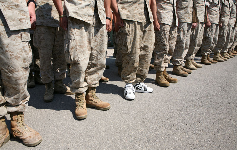 A pair of white Etnies shoes, worn by Lance Corporal Kevin Corr, can be seen among a row of regulation boots during a welcoming-home ceremony at Nellis Air Force Base in Las Vegas, Nevada. Corr accidentally packed his boots prior to returning home with the Marine Forces Rescue Unit, Detachment 2 Bravo Company 6th Motor Transport Battalion. The unit was stationed in Taqaddum, Iraq.
