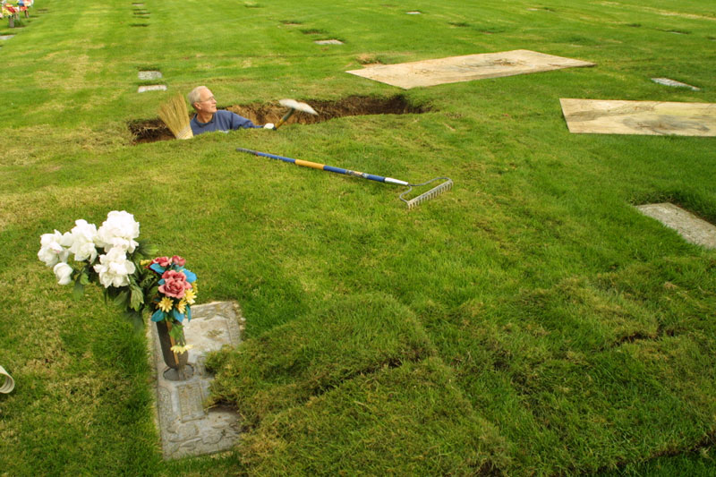 Memorial Gardens cemetery grounds keeper Rick Fabroski cleans out debris from the inside of a freshly dug grave. Though cemeteries and the idea of death is frightful to many, people make a decent living in the business of mortuary science and related jobs. The image is one of several in a photo story on “The Business of Death.{quote}