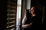 Paris casino table game dealer Kelly Douglas, who is on leave from her job due to COVID-19, stands with her cat Safari April 2, 2020, in Las Vegas. The U.S. Labor Department reported Thursday that 6.6 million people filed for initial unemployment claims in the week ending March 28, double the record 3.3 million from the previous week and far more than what most economists were expecting. (Photo by Ronda Churchill/AFP)