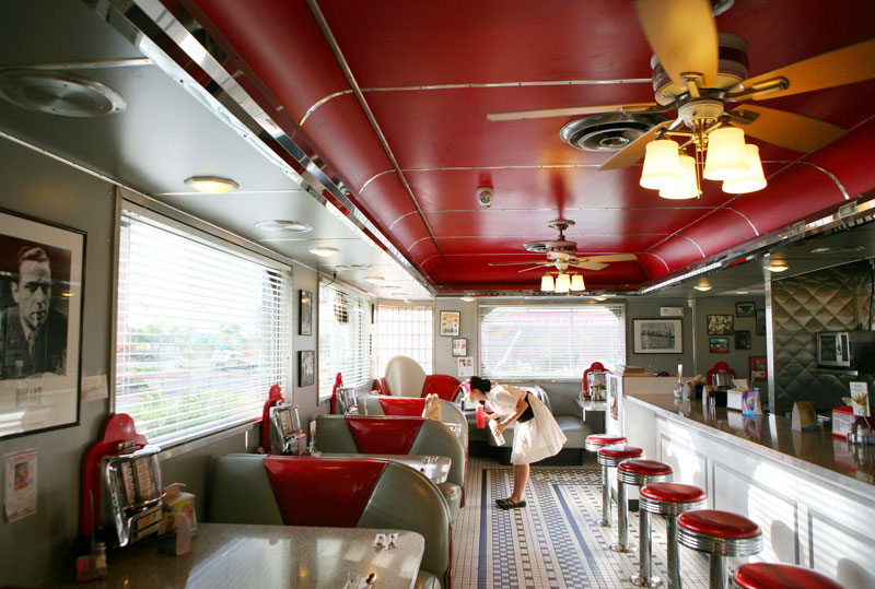 Jamie Cosens bends over to fill salt and pepper shakers at the 1950's-themed Shari's Diner.