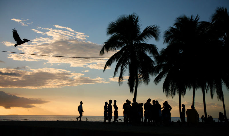 Teenagers socialize during sunset at Crash Boat Beach in Aguadilla, Puerto Rico.