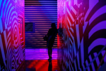 Roqui Theus leans against a wall during an interactive art exhibit on opening day at Meow Wolf’s Omega Mart. The interactive art space is Meow Wolf’s second permanent installation.