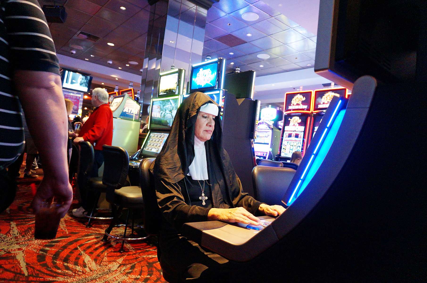 A woman from Texas dressed as a nun plays a slot machine on Halloween in downtown Las Vegas.
