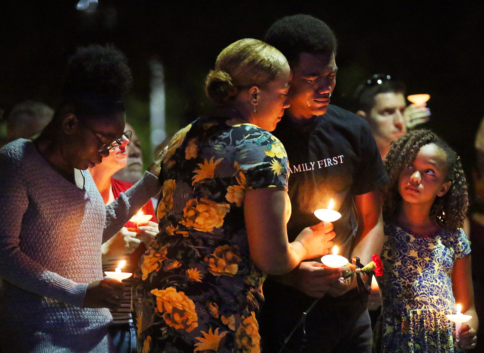 Veronica Hartfield, center, wife of slain LVMPD Officer Charleston Hartfield embraces son Ayzayah Hartfield as daughter Savannah Hartfield, right, looks up during a candlelight vigil. Hartfield was killed Sunday night when a gunman opened fire on the three-day Route 91 Harvest country music festival, leaving 58 dead and over 500 injured in Las Vegas on October 1, 2017.