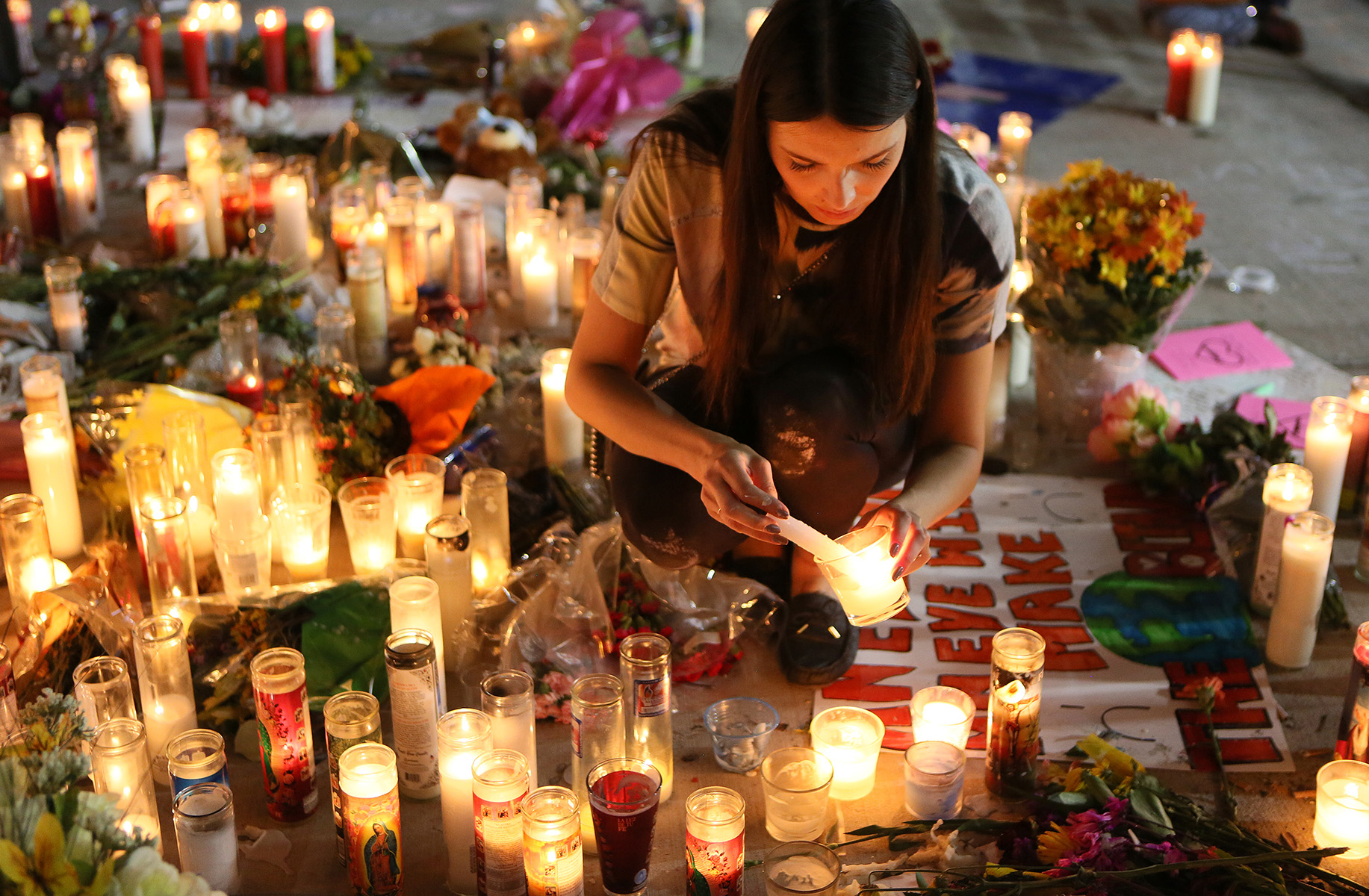 Dashenka, Giraldo, lights candles for the victims of Sunday night's Route 91 Harvest mass shooting at a makeshift memorial on the corner of Las Vegas Boulevard and Sahara Avenue Wednesday, Oct. 4, 2017.