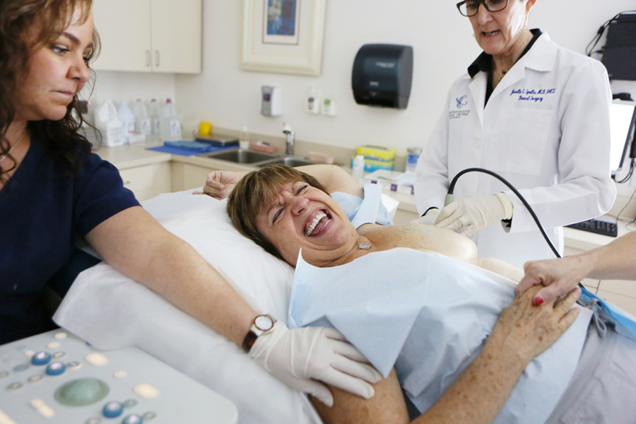 Patient Marilene Nevins, center, endures a procedure to insert a radiotherapy catheter into her left breast after having cancerous tumor removed by Dr. Spotts. She is scheduled to have five days of radiation through the new catheter.
